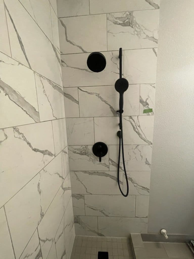 Project Sleek Bathroom Transformation with Black Fixtures and Marble-like Tiles image
